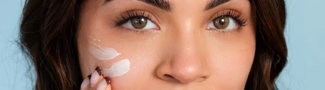 Woman applying Bohemia Skin moisturizer to face for clean, radiant skincare results.