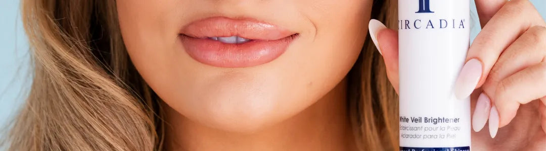 Woman with smooth skin holding Circadia White Veil Brightener skincare product