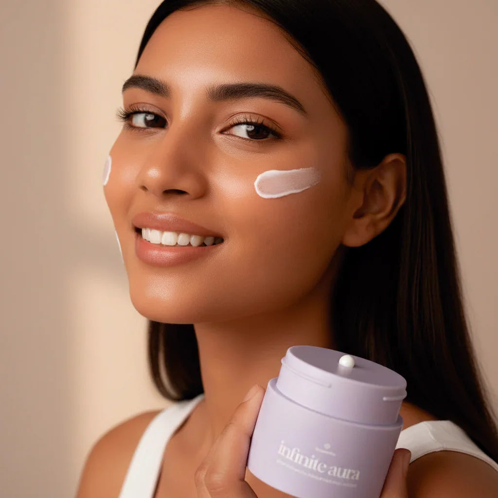 Smiling woman applies Bohemia Skin cream, promoting clean holistic skincare in soft light.