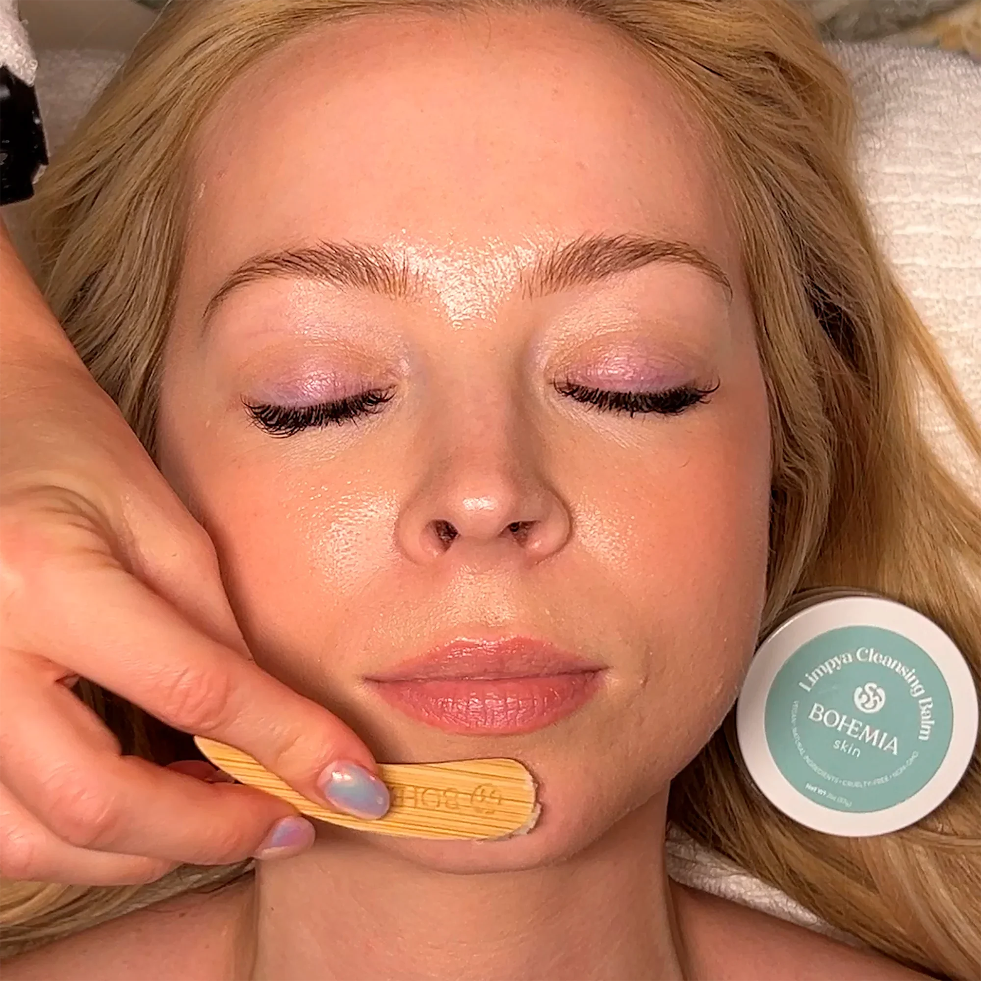 Woman receiving Bohemia Skin holistic facial treatment with cleansing balm and wooden spatula