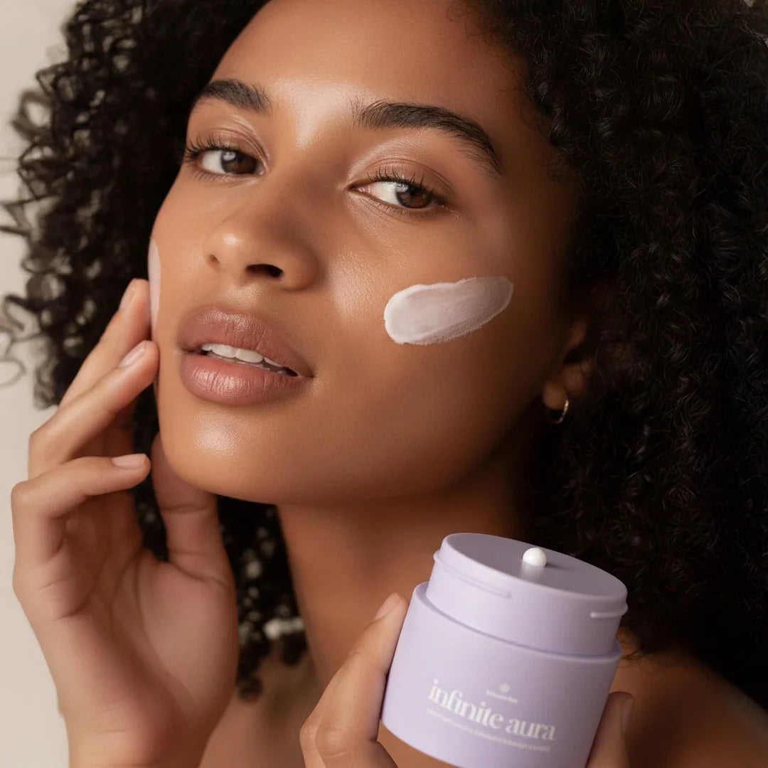 Woman applying Bohemia Skin Infinite Aura cream, showcasing clean, radiant skincare results.
